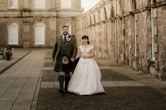 Bride and groom hold hands at The Venue, Eskmills